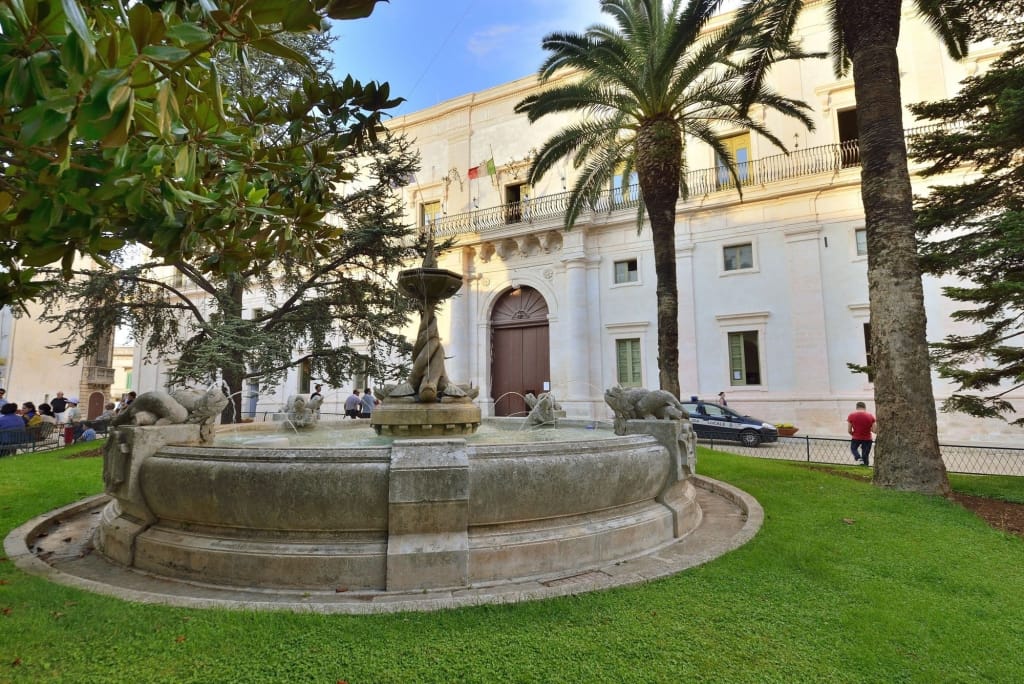 Martina Franca Piazza Roma Fontana e verde di Piazza Roma a Martina Franca con sfondo il Palazzo Ducale.