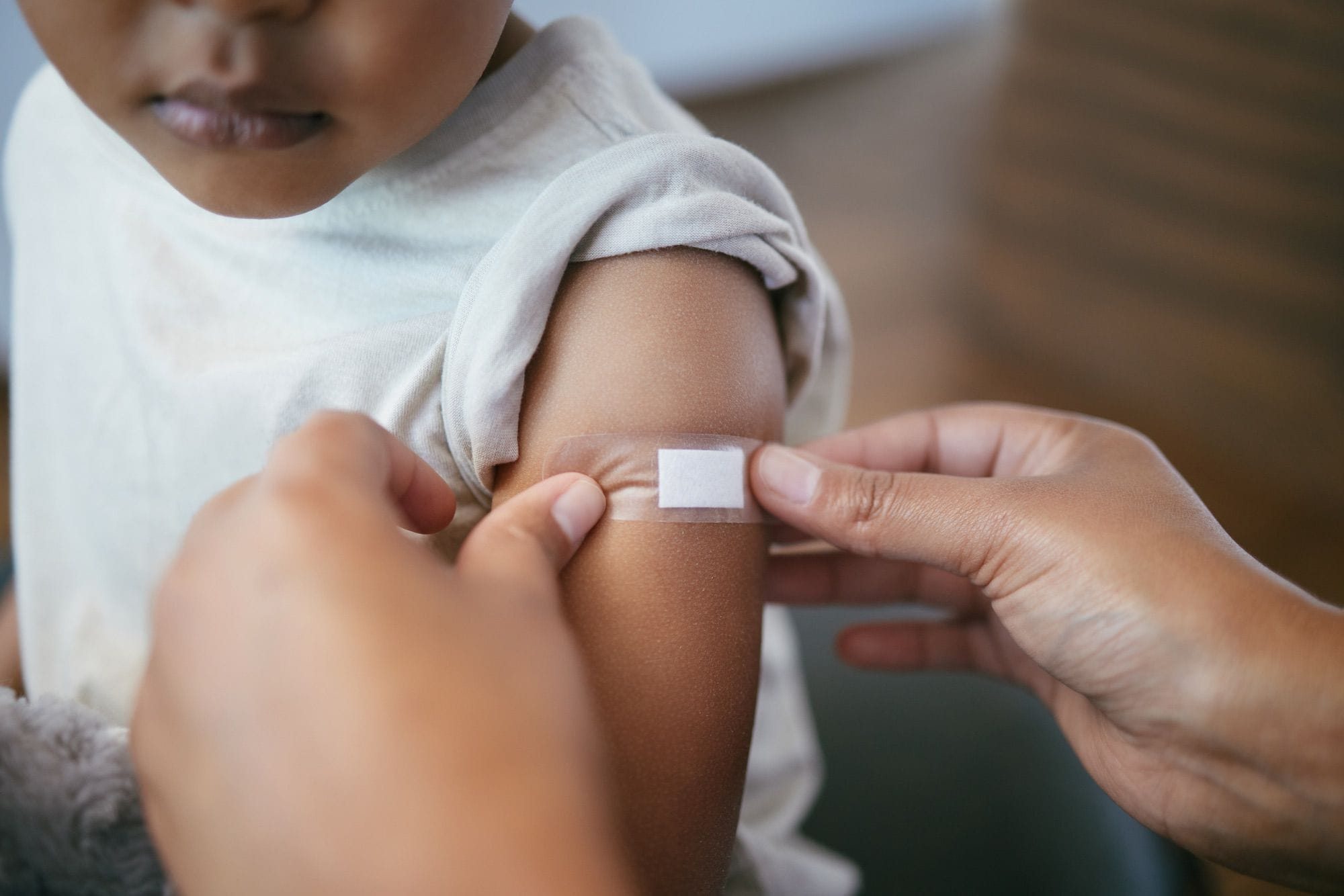 Progetti rivolti ai bambini del Rotary Club Un mendico appone un cerotto sul braccio di un bimbo.